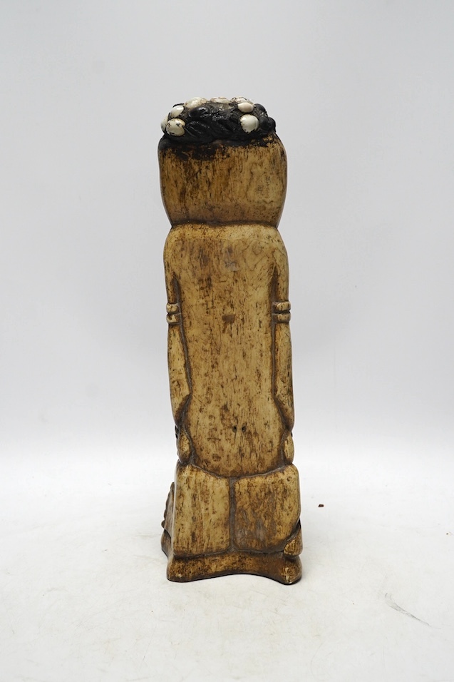A West African carved animal bone fertility figure, 34cm. Condition - fair